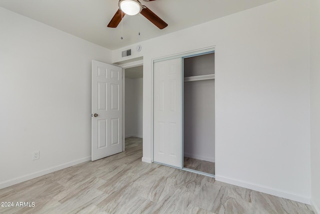 unfurnished bedroom with ceiling fan and a closet