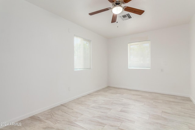 unfurnished room featuring ceiling fan and a healthy amount of sunlight