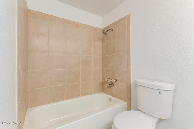 bathroom featuring toilet and tiled shower / bath