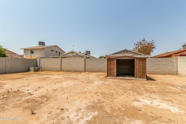 view of yard featuring central air condition unit and a storage unit