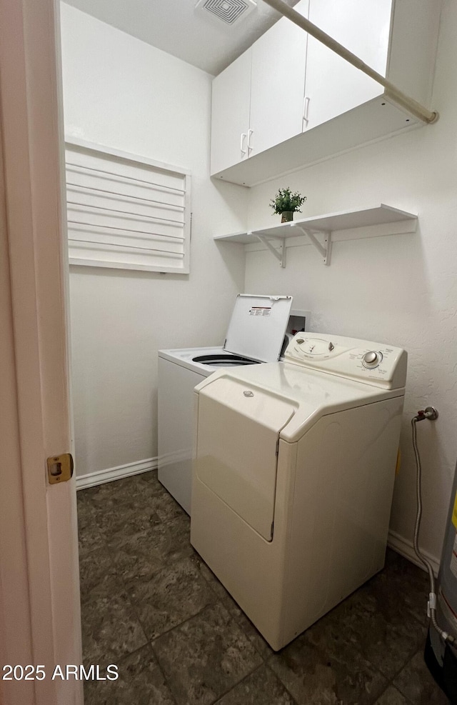 clothes washing area featuring cabinets and washing machine and dryer