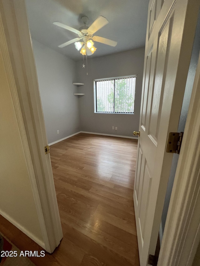 empty room with hardwood / wood-style floors and ceiling fan