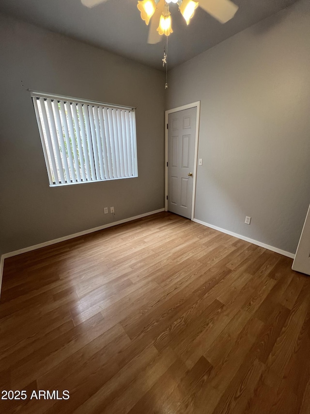 unfurnished room with a wealth of natural light, ceiling fan, and hardwood / wood-style floors