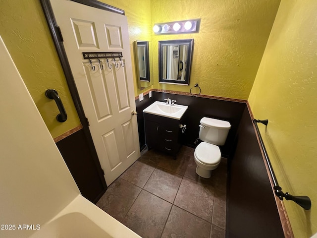 bathroom with toilet, vanity, and tile patterned floors