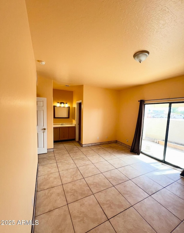 spare room featuring light tile patterned floors and a textured ceiling