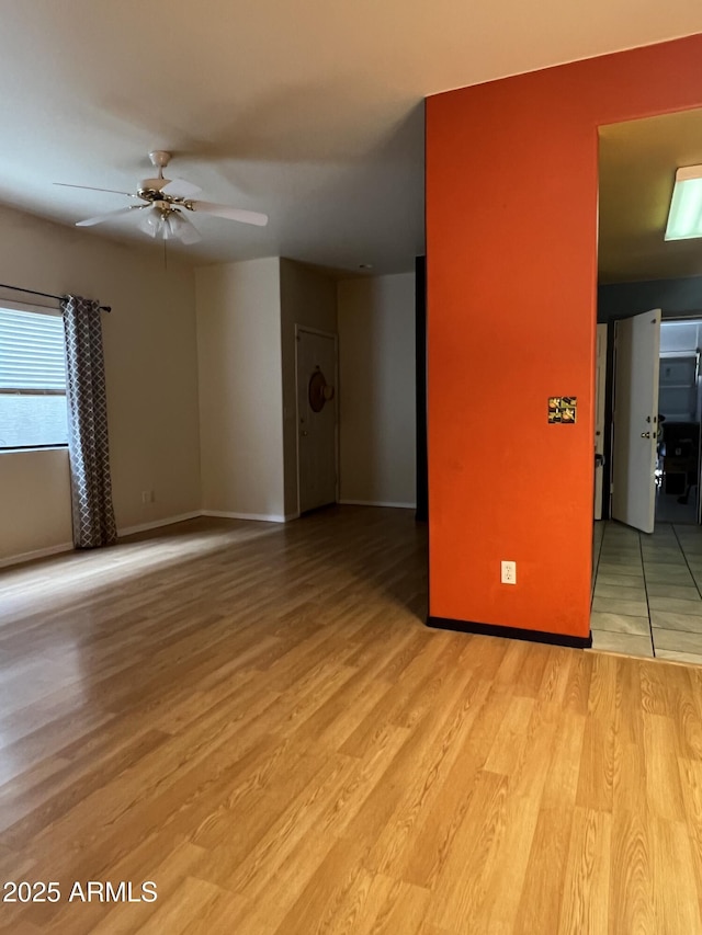 unfurnished room with ceiling fan and light wood-type flooring