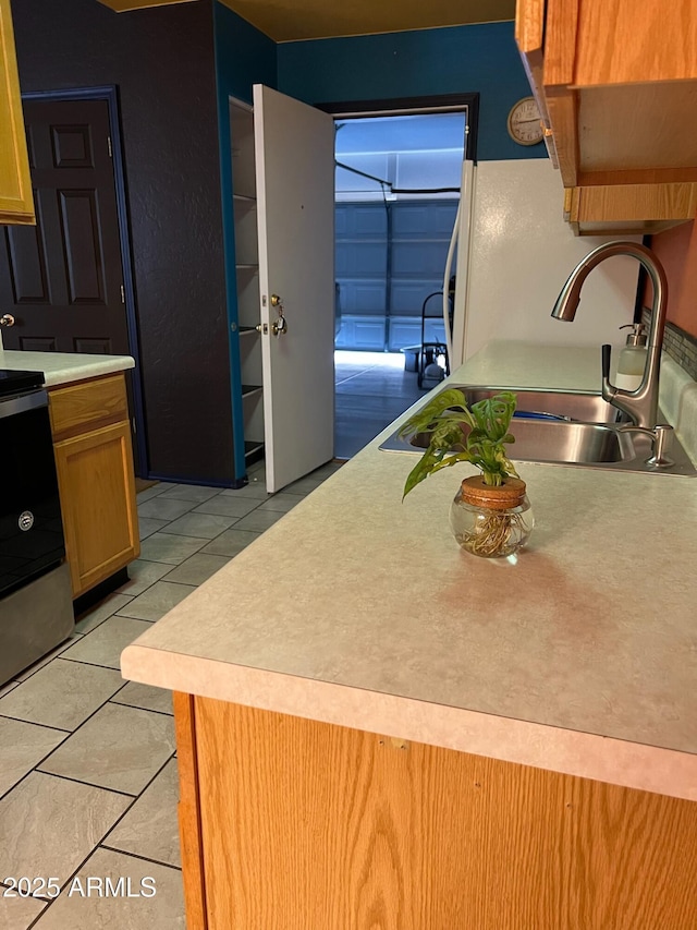 kitchen featuring sink, light tile patterned floors, white refrigerator, and range