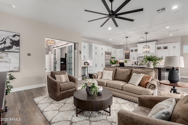 living room with ceiling fan, sink, and beverage cooler