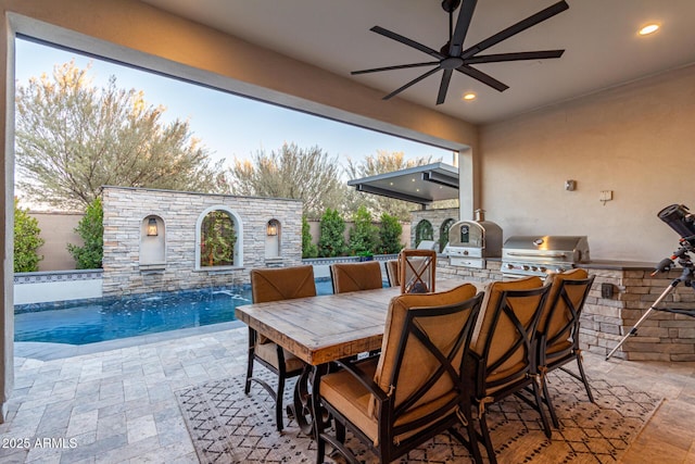 view of patio / terrace with pool water feature, an outdoor kitchen, a fenced in pool, and area for grilling