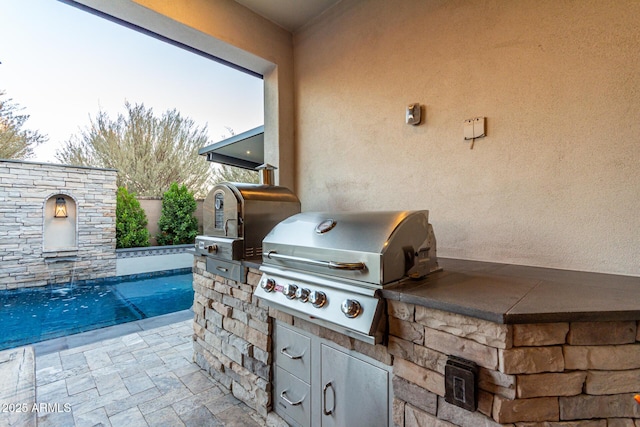 view of patio with pool water feature and area for grilling