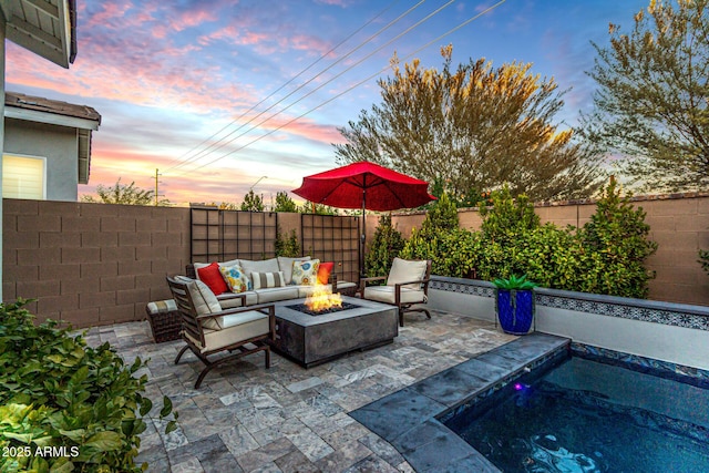 patio terrace at dusk featuring an outdoor living space with a fire pit