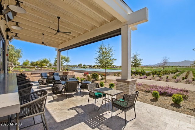 view of patio / terrace featuring ceiling fan and a mountain view