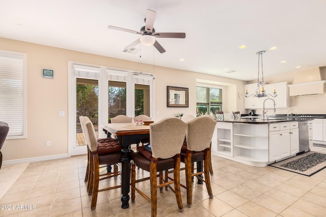 tiled dining room featuring sink and ceiling fan with notable chandelier