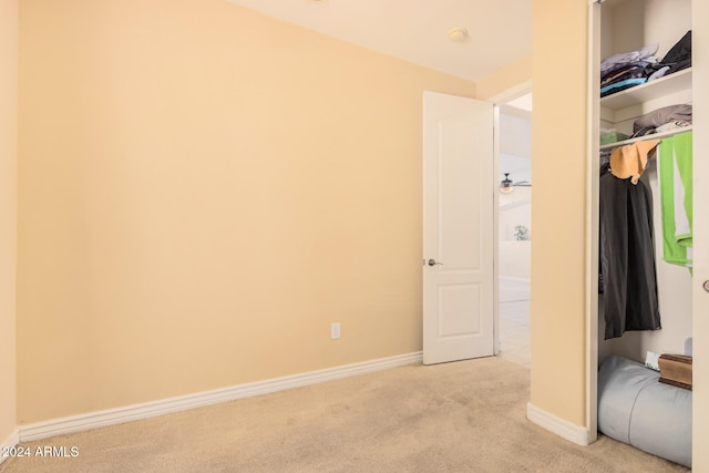 unfurnished bedroom with light carpet and a closet