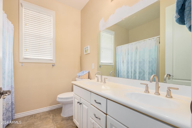 bathroom featuring toilet, vanity, and tile patterned flooring