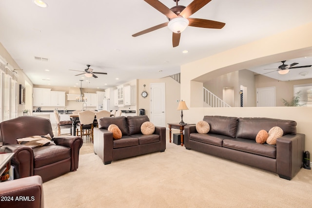 carpeted living room with ceiling fan