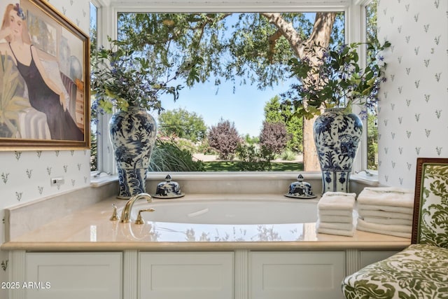 bathroom with wallpapered walls and a bath