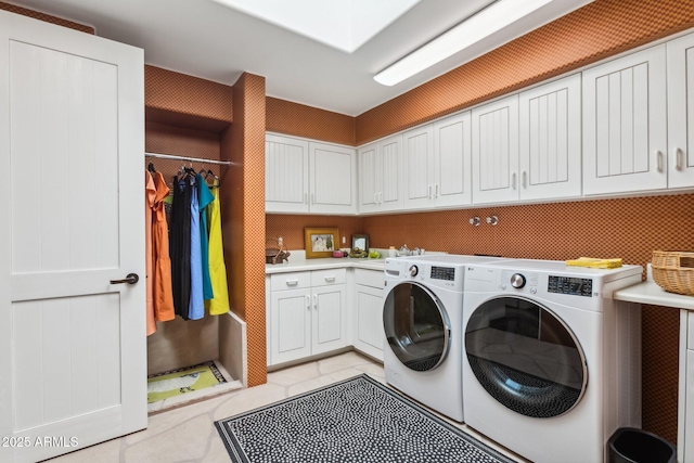 clothes washing area with light tile patterned flooring, cabinet space, and washer and dryer