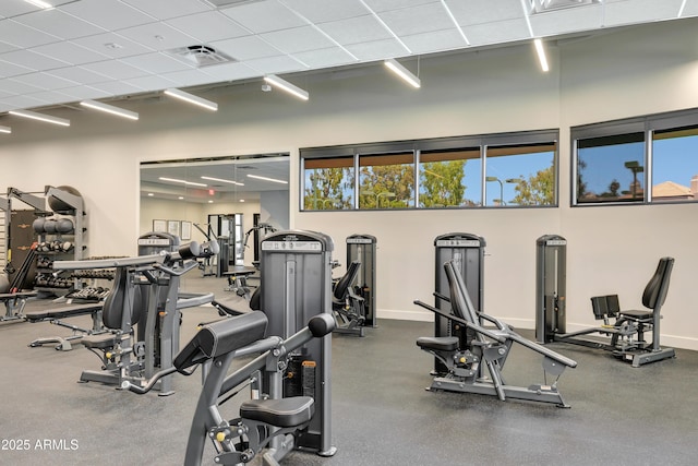 exercise room featuring baseboards, visible vents, and a healthy amount of sunlight