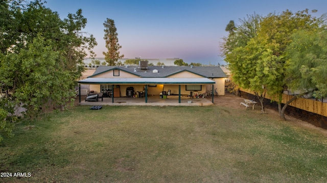 6415 W Roosevelt St, Phoenix, AZ 85043 - back of house at dusk featuring a patio area and a chimney