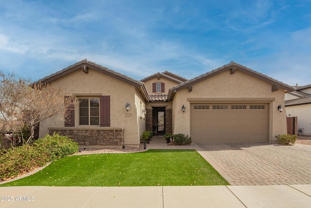 mediterranean / spanish-style house featuring stucco siding, a garage, stone siding, a tiled roof, and decorative driveway