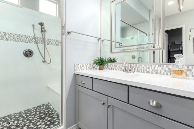 full bath with tasteful backsplash, walk in shower, and vanity