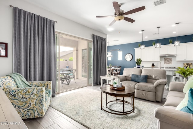 living area with visible vents and a ceiling fan