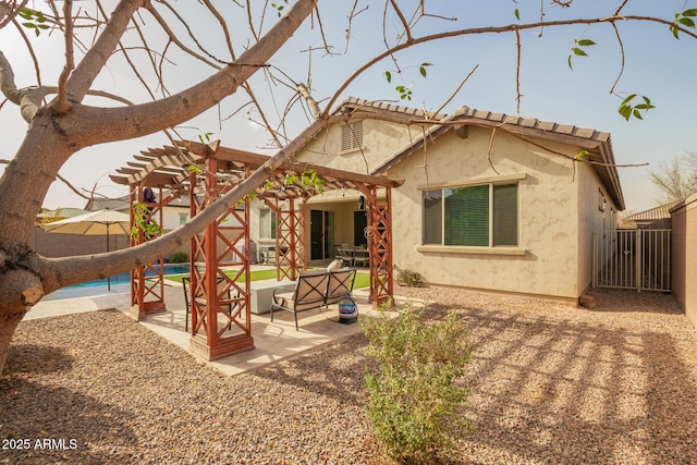 back of house featuring stucco siding, a fenced backyard, an outdoor pool, a pergola, and a patio