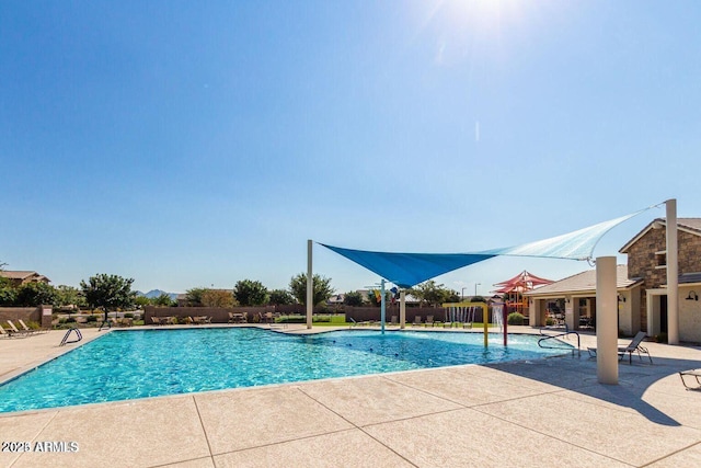 community pool featuring a patio and fence