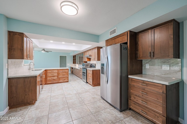 kitchen featuring backsplash, sink, ceiling fan, appliances with stainless steel finishes, and kitchen peninsula