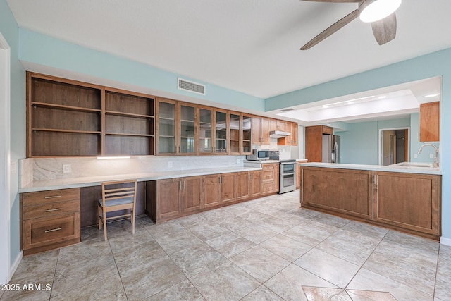 kitchen featuring ceiling fan, sink, kitchen peninsula, and stainless steel appliances