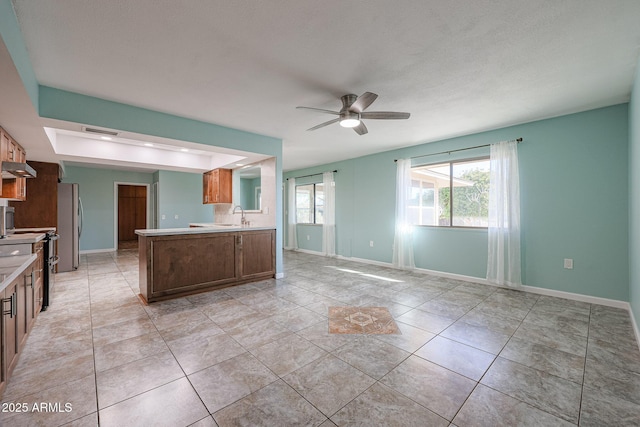 kitchen featuring stainless steel refrigerator, ceiling fan, plenty of natural light, and sink