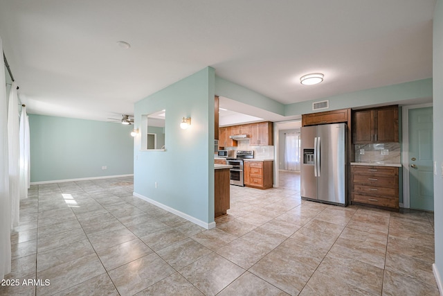 kitchen featuring backsplash, ceiling fan, light tile patterned floors, and stainless steel appliances