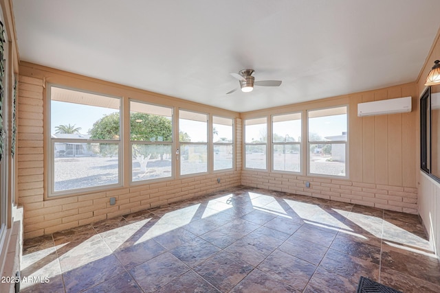 unfurnished sunroom with an AC wall unit, plenty of natural light, and ceiling fan