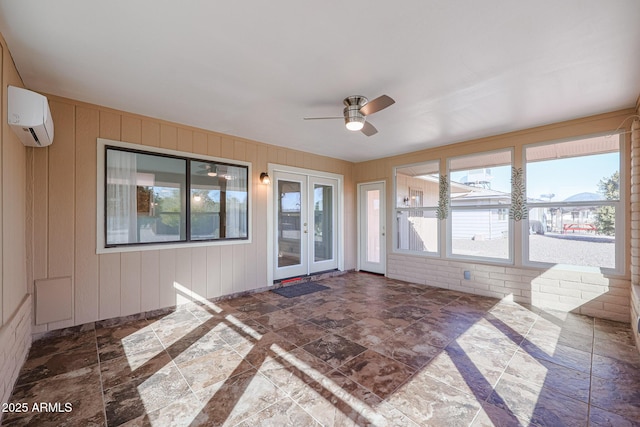 unfurnished sunroom with an AC wall unit and ceiling fan