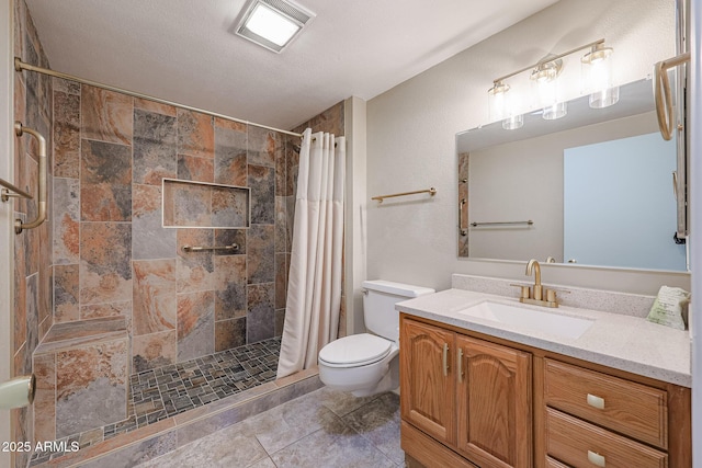 bathroom featuring a textured ceiling, vanity, toilet, and walk in shower