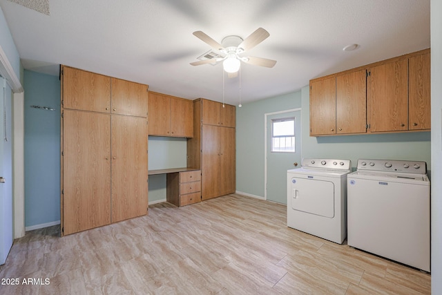 laundry room with cabinets, light wood-type flooring, washer and dryer, and ceiling fan