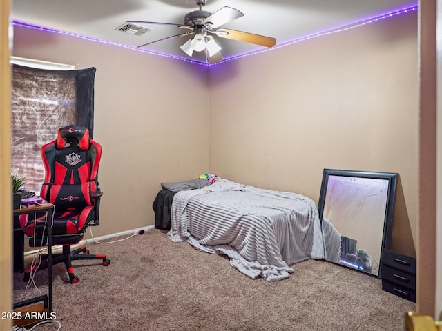 carpeted bedroom with visible vents, a ceiling fan, and baseboards