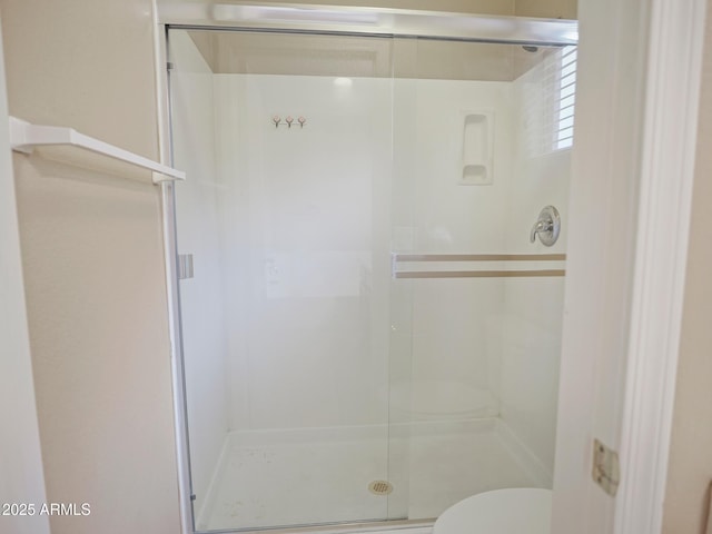 full bath featuring a shower stall and toilet