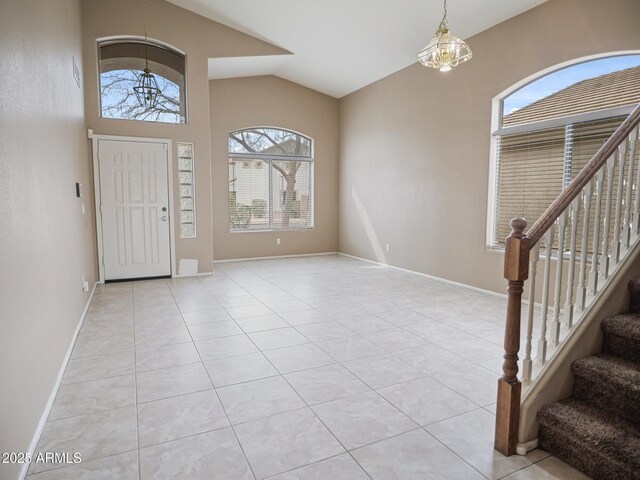 entryway with baseboards, light tile patterned flooring, stairs, and vaulted ceiling