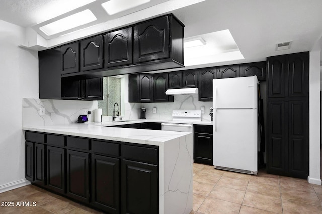8202 W Turney Ave, Phoenix, AZ 85033 - kitchen with white appliances, under cabinet range hood, a peninsula, decorative backsplash, and dark cabinets
