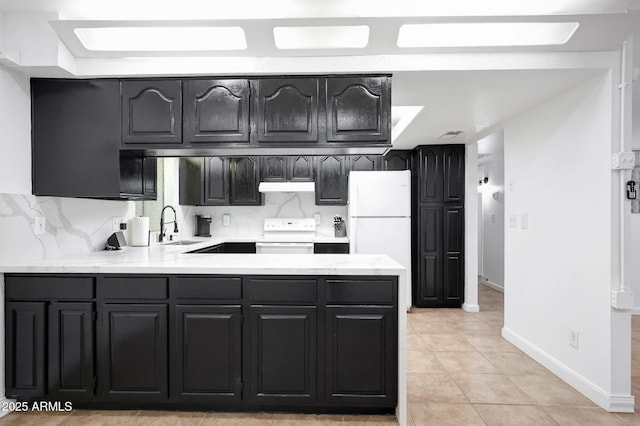 8202 W Turney Ave, Phoenix, AZ 85033 - kitchen with white appliances, a peninsula, light countertops, light tile patterned floors, and under cabinet range hood