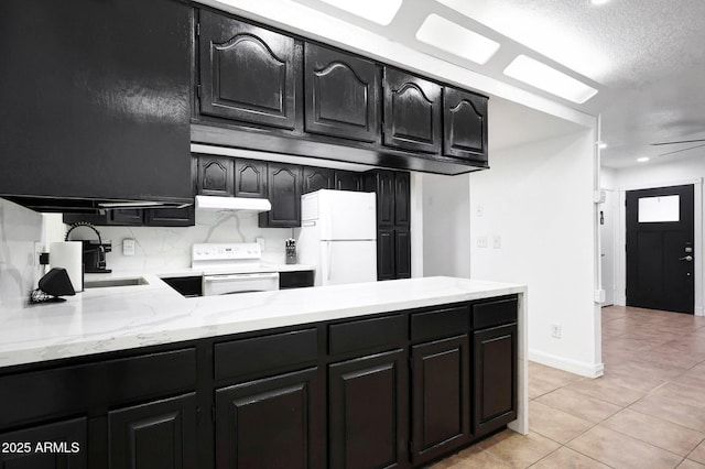 8202 W Turney Ave, Phoenix, AZ 85033 - kitchen featuring white appliances, under cabinet range hood, dark cabinets, light tile patterned floors, and a textured ceiling