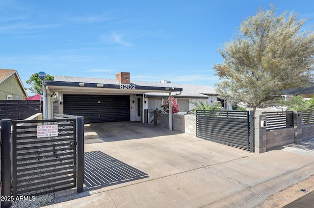 8202 W Turney Ave, Phoenix, AZ 85033 - view of front of home featuring driveway, an attached garage, a fenced front yard, and a gate