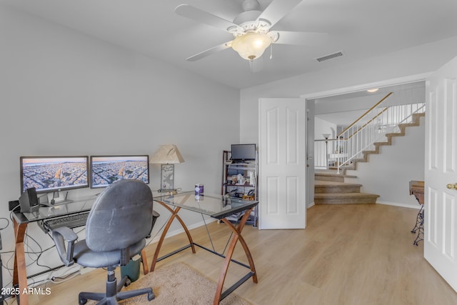 office with light wood-style floors, baseboards, visible vents, and ceiling fan