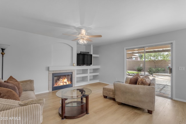 living room with a fireplace, wood finished floors, and baseboards