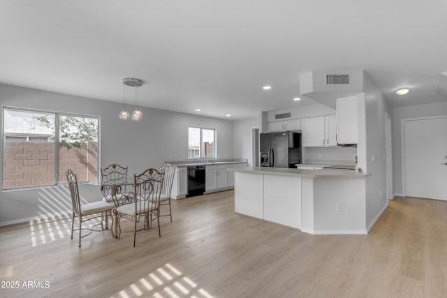 kitchen featuring black appliances, light wood finished floors, light countertops, and white cabinets