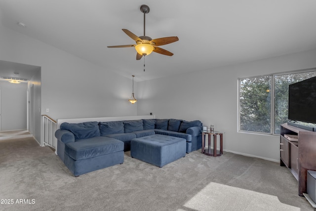 carpeted living room with lofted ceiling, ceiling fan, and baseboards