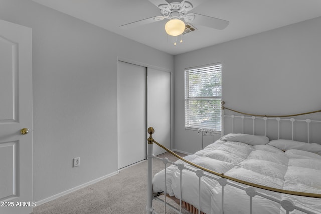 carpeted bedroom with ceiling fan, visible vents, baseboards, and a closet