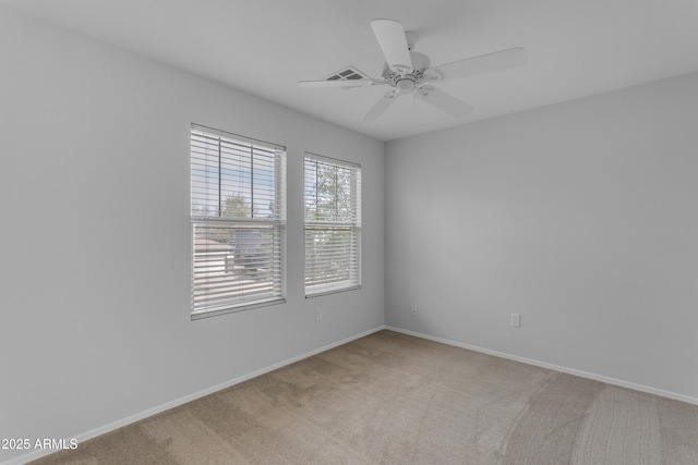 unfurnished room with a ceiling fan, light colored carpet, and baseboards